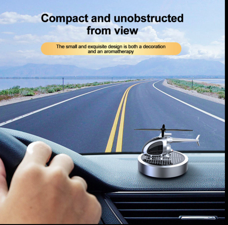 Car dashboard with a compact helicopter-shaped device, scenic road in the background