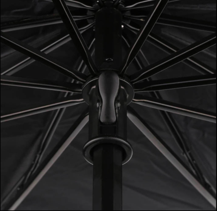 Close-up of a black umbrella with visible ribs against a dark background