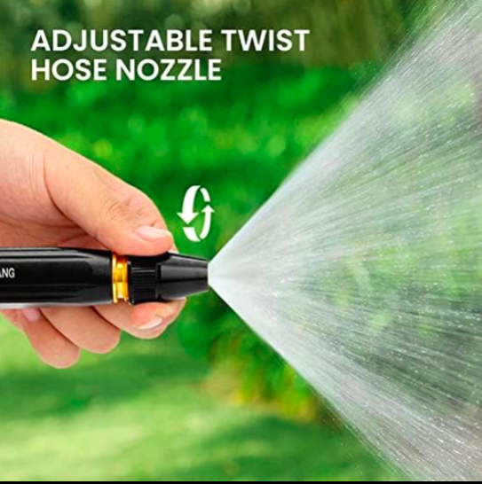 Hand holding an adjustable twist hose nozzle with water spraying, against a green background.