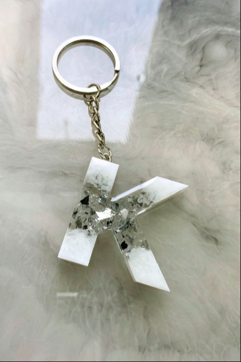 Keychain with a white geometric design on a marble surface