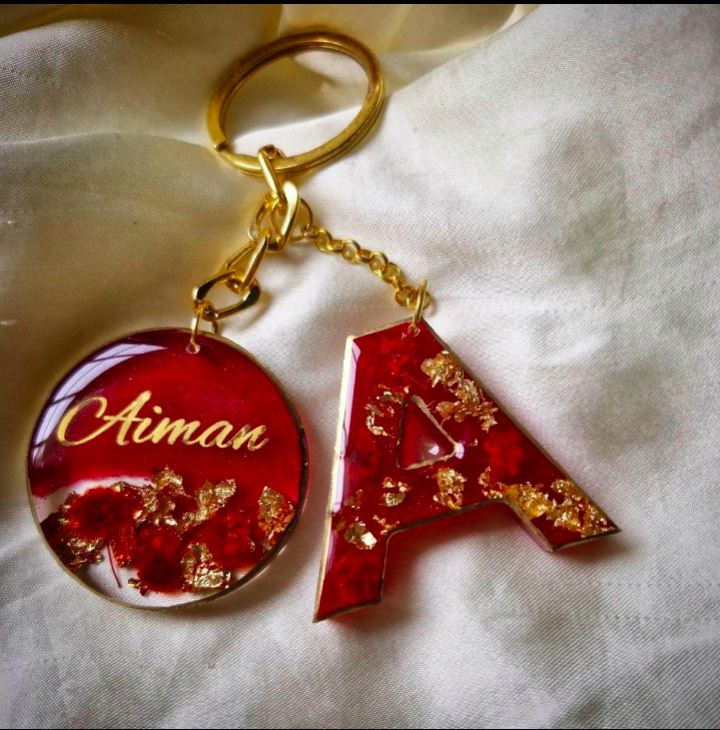 Keychain with red and gold design on a white fabric background