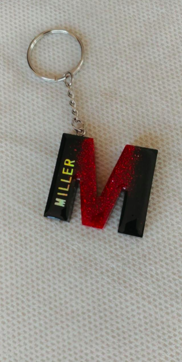 Keychain with 'Miller' and a red 'M' on a textured surface
