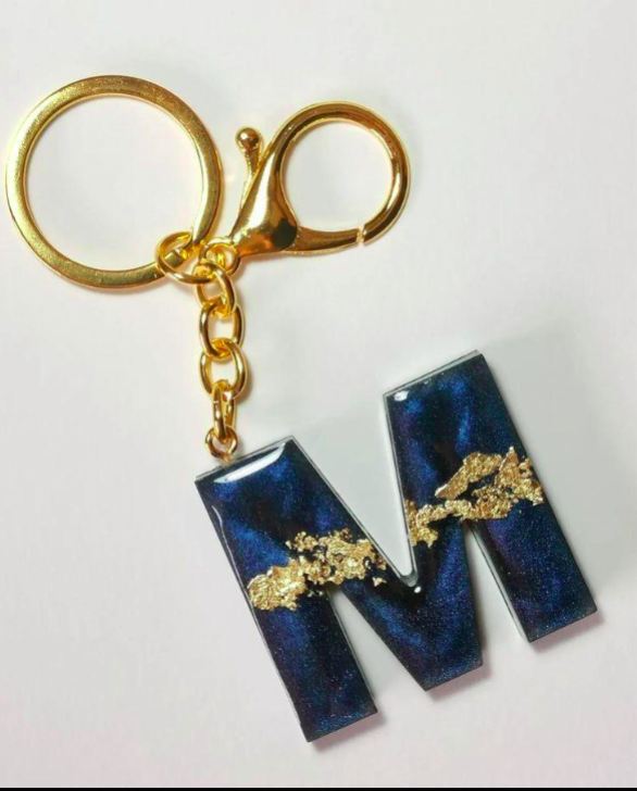 Keychain with a blue and gold letter 'M' design on a white background
