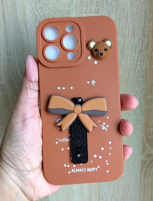 Phone case with bear and bow design held by a hand on a wooden surface