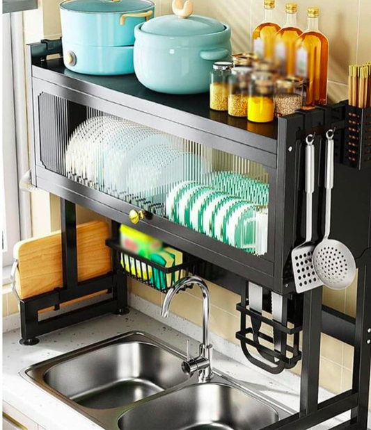 Kitchen sink area with a black dish rack, turquoise pots, and various kitchen utensils.