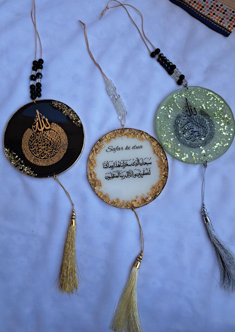 Three decorative items with tassels on a light blue background
