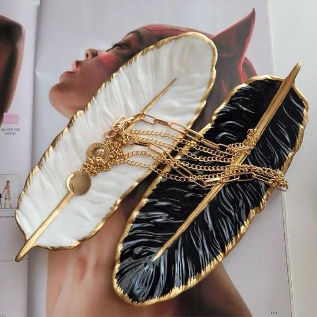 Feathered clutch with gold accents on a magazine page