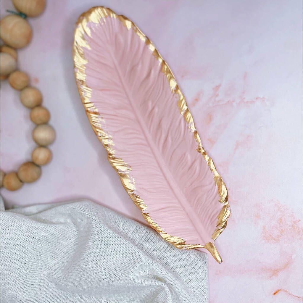 Pink feather-shaped dish with gold edge on a marble surface