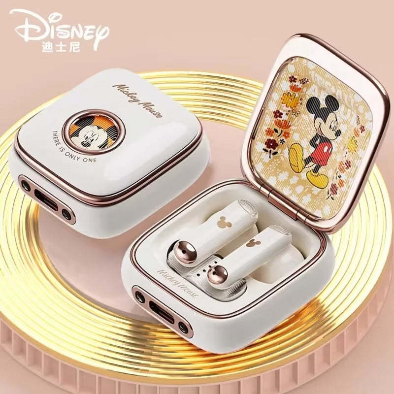 Disney-themed wireless earbuds with case on a decorative stand