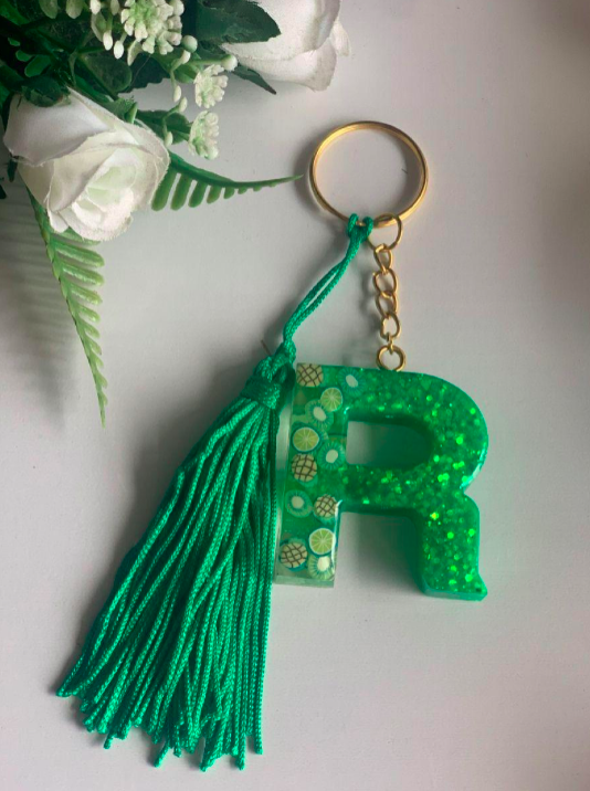 Green letter 'R' keychain with tassel on a light background