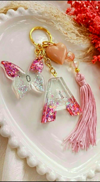 Decorative keychain with butterfly charm and pink tassel on a white heart-shaped dish.