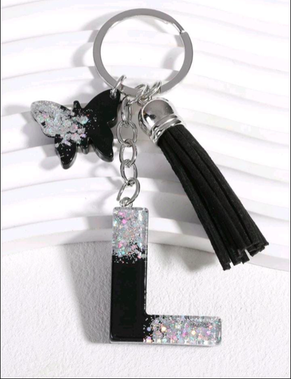 Keychain with butterfly, letter 'L', and tassel on a white background