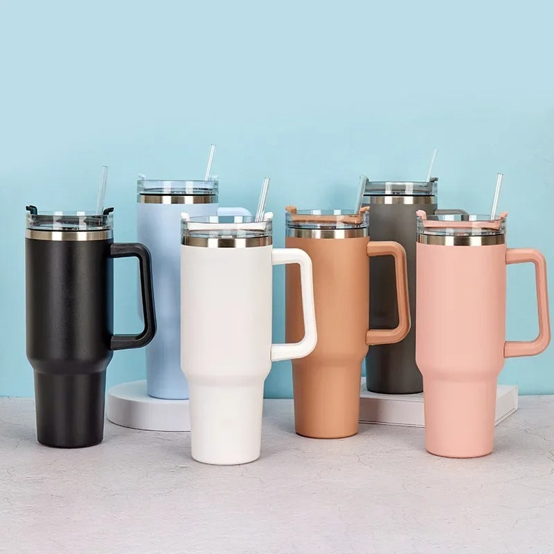 Set of colorful insulated travel mugs with handles on a light blue background