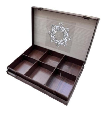 Open wooden jewelry box with compartments on a white background