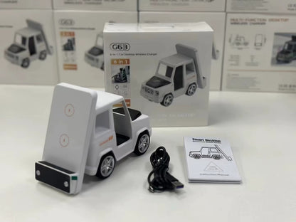 White toy truck with charging stand, cable, and manual on a white surface with product packaging in the background.