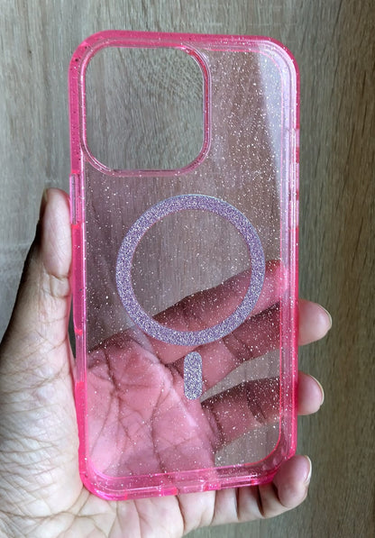 Pink glittery phone case with a ring holder held in a hand against a wooden background